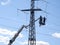 A team of electricians install grounding on the wires of a high-voltage overhead line. part of the image is blurred.