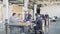 A team of engineers holds a meeting at a large table. In the background, the employee goes past two colleagues who are