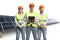 Team of engineers wearing reflective vests amd helmets on a photovoltaic field