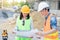 Team of engineers wearing yellow helmet and working at construction site