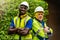 Team factory worker technician engineer men standing confidence with green working suite dress and safety helmet. Background of