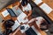 Team of female accountants preparing annual financial report working with papers using laptops sitting at desk in office