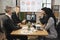 Team of four focused multiethnical businesspeople looking at laptop, having video conference