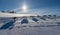 A team of four husky sled dogs running on a snowy wilderness road.