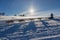 A team of four husky sled dogs running on a snowy wilderness road.