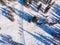 Team friends snowboarders and skiers rides along track through forest, aerial top view