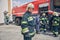 Team of happy firefighters learning on trucks at fire station