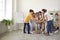 Team of happy kids together with their teacher stacking their hands during class