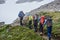 Team of hikers walking on mountain path.