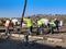 Team of men pouring a concrete foundation in a new home development