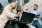 Team of multiethnical diverse business people, two men and two women, standing in modern office, discussing and working