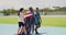 Team of patriotic olympic athletes celebrating victory, walking and cheering on a track outside. Three diverse american