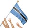 Team of peoples hands raising the Botswana national flag