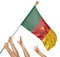 Team of peoples hands raising the Cameroon national flag