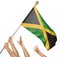 Team of peoples hands raising the Jamaica national flag