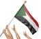 Team of peoples hands raising the Sudan national flag