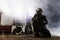 Team of professional firefighters holding water hose in front of a firetruck with smoke in the air. Half silhouette