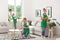 Team of professional janitors in uniform cleaning room