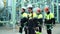 Team of professional workers in protective clothes and hard hat walking on production plant site