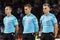 Team of referees standing on a grassy soccer field in blue uniforms in Armenia