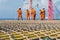 A team of riggers or roughnecks installing landing net on a helipad of a construction work barge