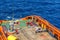 A team of riggers or roughnecks landing a personal transfer basket on anchor handling tug boat