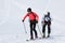 Team ski mountaineers climb on mountain on skis strapped to climbing skins