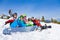 Team with snowboards and goggles sitting in a row