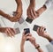 The team that stays connected. Low angle shot of a group of colleagues using their smart phones in synchronicity.