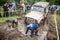 Team on Uaz 469 setting a recovery sand tracks to overcome a hard pit.