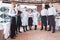 A team of waiters conduct a briefing on the summer terrace of the restaurant