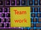 Team work the word is written on yellow paper that lies on the keyboard. reminder about work