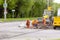 A team of workers with the help of special equipment break open the asphalt on the carriageway on the street
