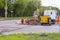 A team of workers with the help of special equipment break open the asphalt on the carriageway on the street