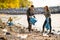 Team of young dedicated volunteers cleaning beach on sunny day