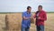 Teamwork agriculture lifestyle smart farming concept. Two men farmers workers studying a haystack in a field on digital