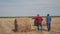 Teamwork agriculture smart farming concept. Two men farmers lifestyle workers walking studying a haystack in field on