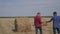 Teamwork agriculture smart farming concept. two men farmers workers walking studying a haystack lifestyle in field on