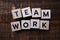 Teamwork alphabet letters on wooden background