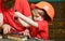 Teamwork and assistance concept. Boy, child busy in protective helmet learning to use screwdriver with dad. Father