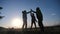 Teamwork business journey concept win. Happy family team man, woman and kids sunset silhouette help shake hands victory