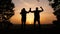 Teamwork. business a journey concept win. happy family team tourists man and woman sunset silhouette hands up teamwork