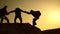 Teamwork of business people. Climbers silhouettes stretch their hands to each other, climbing to the top of hill