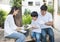 Teamwork of caucasian father, asian mother and young son leaning to plant tree in pot at front yard at home, happy young family