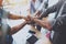 Teamwork concept.Group of three coworkers join hand together during their meeting. Horizontal.Blurred background.