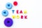 Teamwork concept. Text teamwork lined with colored letters near toy gears on white background top view copyspace