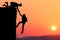 Teamwork couple hiking help each other trust assistance silhouette in mountains, sunset. Teamwork of man and woman hiker helping e