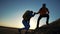 teamwork. help travel silhouette concept. group team of tourists lends helping hand climb the cliffs mountains