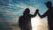 Teamwork lifestyle business journey concept win. Team tourists man and woman sunset silhouette help shake hands success