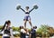 Teamwork, motivation or cheerleader in air with people outdoor in training routine or sports event. Jump, sky or girl by